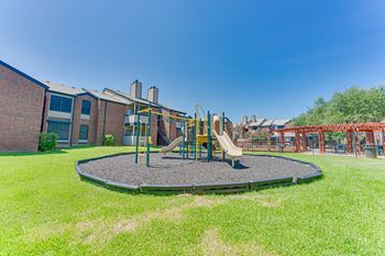 A playground with a slide and a trampoline.
